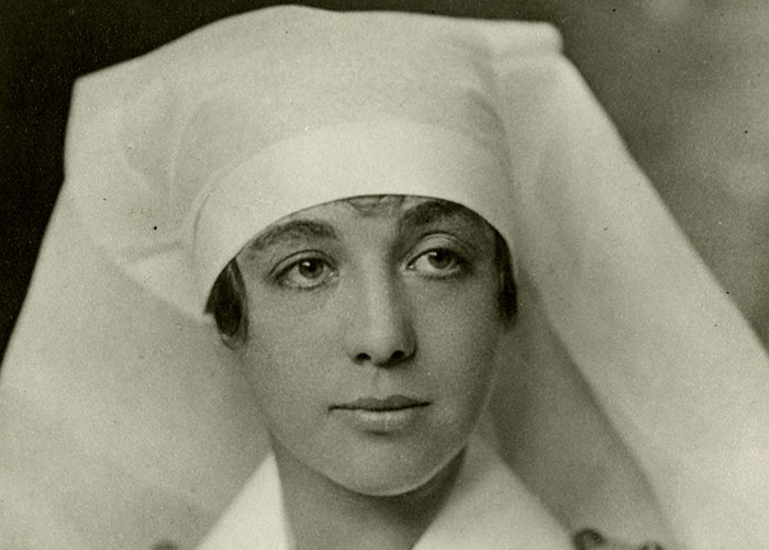 Black and white portrait of Helen Mary Kendall in nursing uniform. She is approximately 27 years of age, wearing a white nurse's cap, cotton dress with brass buttons, white apron, and large white collar.